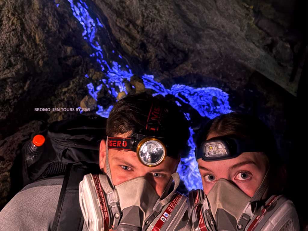 Ijen blue fire phenomenon with sulfur miners at Ijen Crater in East-Java